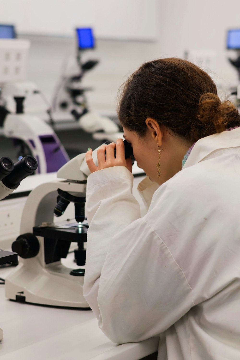 A scientist looking through a microscope in a laboratory