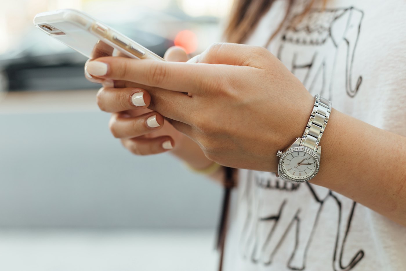 A woman reading a message on her phone outdoors